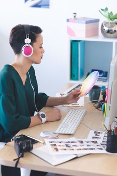 Female graphic designer working on computer at desk in the office