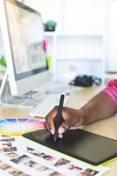 Graphic designer working on graphic tablet at desk in office