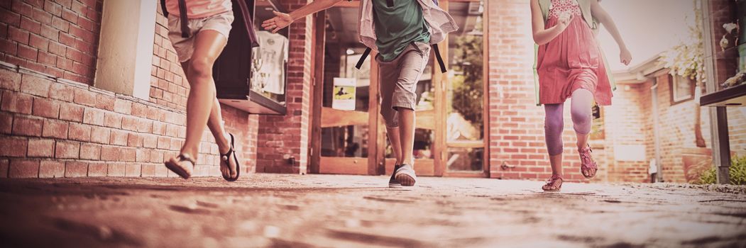 Kids running in school corridor on sunny day