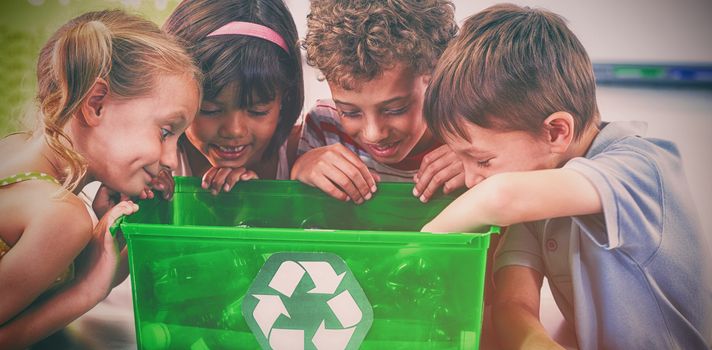 Children looking at bottles in recycling box at classroom 