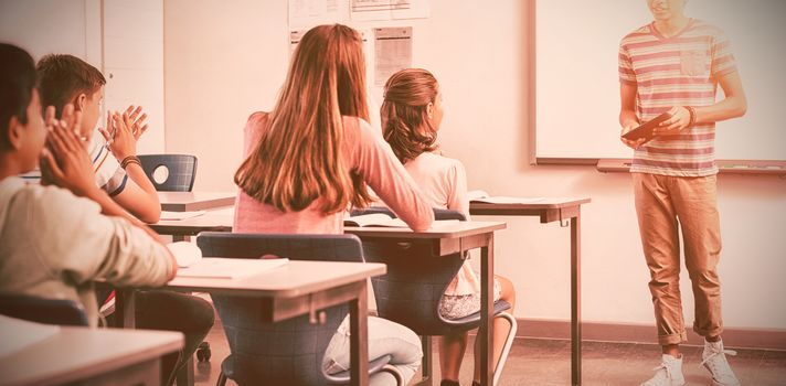 Schoolboy giving presentation in classroom at school