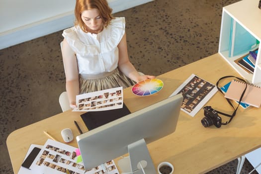 High angle view of female graphic designer working at desk in office
