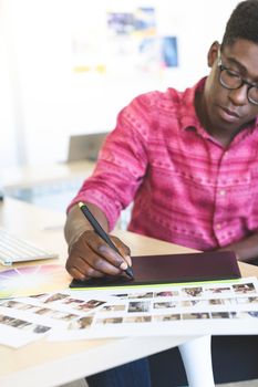 Graphic designer working on graphic tablet at desk in office