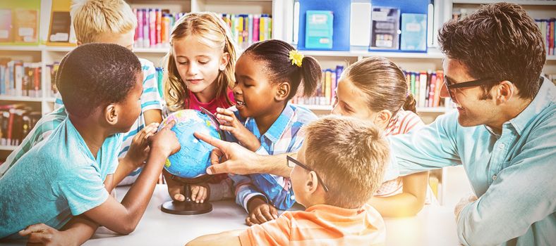 Teacher and kids discussing globe in library at school