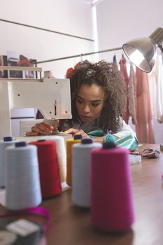 Front view of female fashion designer working with sewing machine