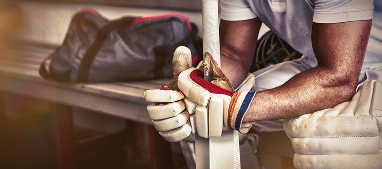 Stressed cricket player sitting on bench at locker room, Close-up