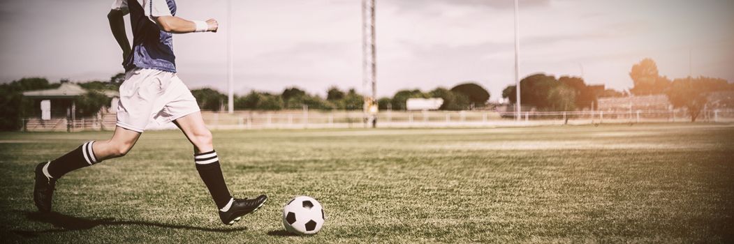 Female football player practicing soccer in a stadium