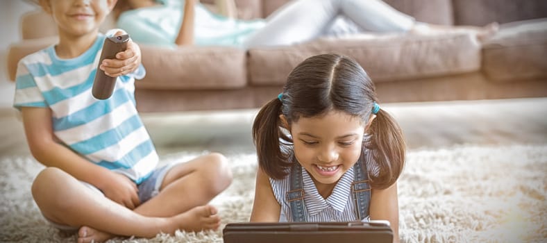 Boy watching television and girl using digital tablet in living room at home
