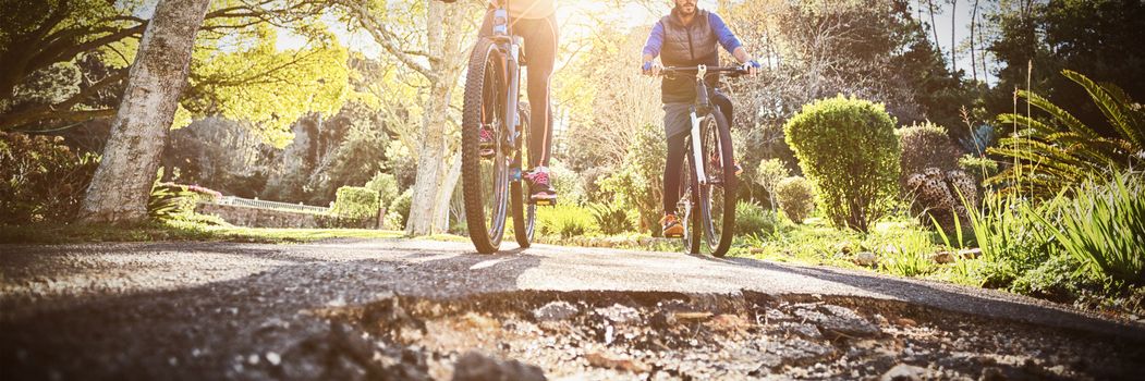 Low angle view of biker couple cycling on countryside road