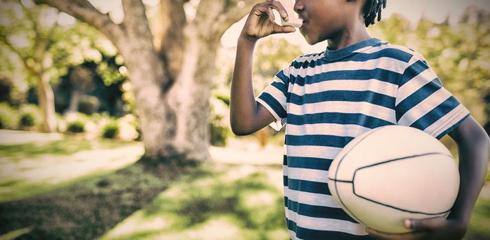 Boy using asthma inhaler in the park on a sunny day