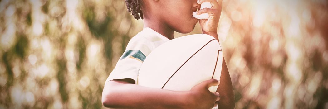 Child is using an asthma inhaler in park