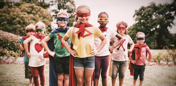 Children wearing superhero costume standing in the park