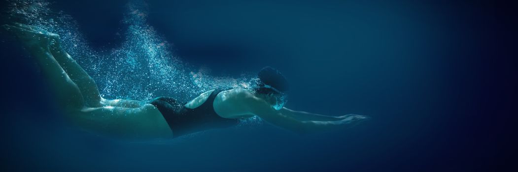 Athletic swimmer training on her own in the swimming pool at the leisure centre