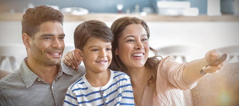 Parents and son watching television in living room at home