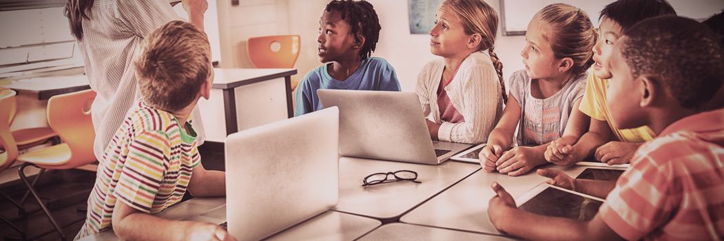 Teacher showing new technology to students in classroom