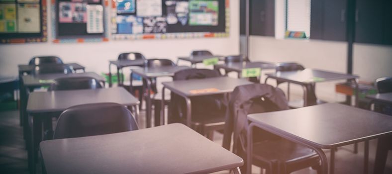 Interior of empty classroom with desks and chairs