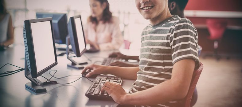 Portrait of student using computer in classroom at school