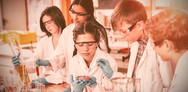 Attentive school kids doing a chemical experiment in laboratory at school