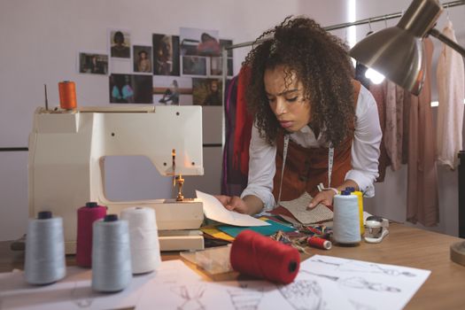 Front view of female fashion designer working in design studio