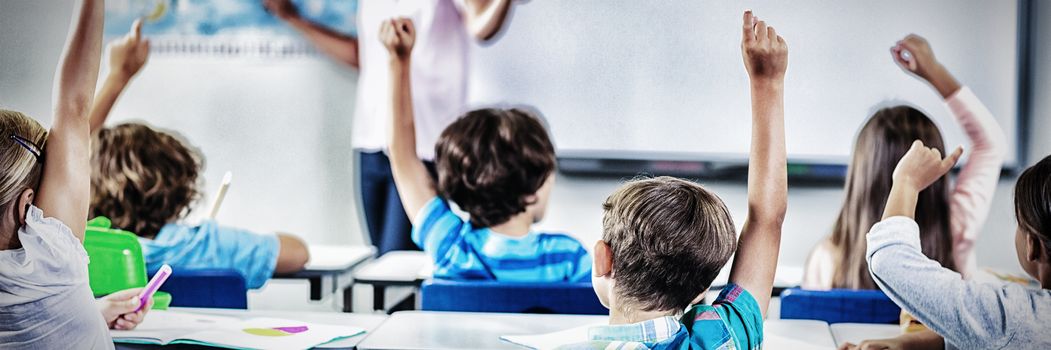 Kids raising hand in classroom at school