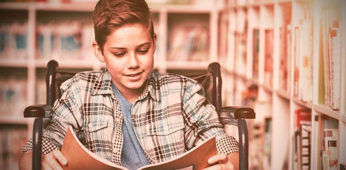 Disabled schoolboy reading book in library at school