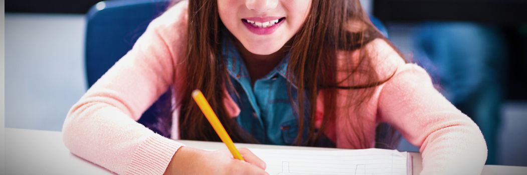 Portrait of smiling schoolgirl studying in classroom at elementary school