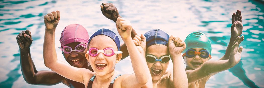 Portrait of cheerful children enjoying at poolside