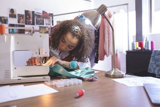 Front view of female fashion designer working with sewing machine