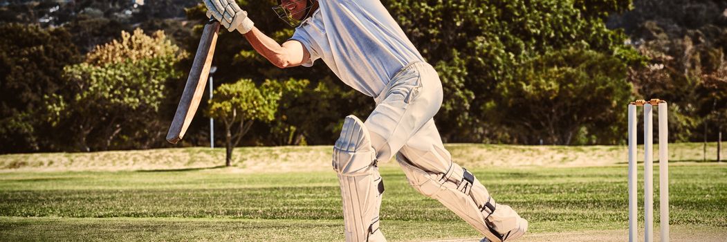 Full length of cricketer playing on field during sunny day