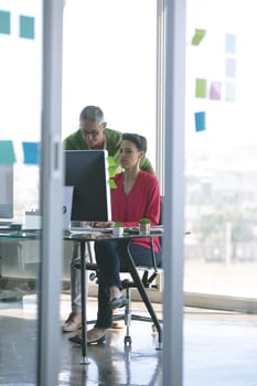 Front view of attentive business people working at desk in creative office