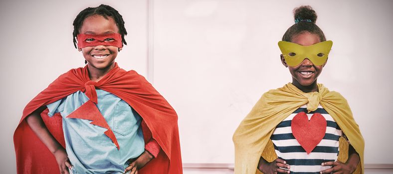 Boy and girl in eye mask and cape standing over white background