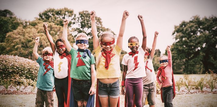 Children wearing superhero costume standing in the park