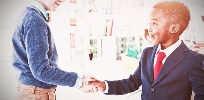 Kids as business executives shaking hands in office