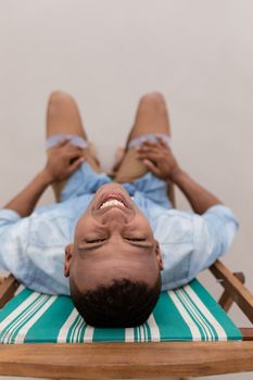 Portrait of African american man smiling while relaxing on a beach chair at beach