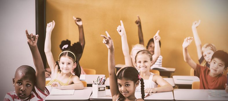 Students raising hands in classroom at school