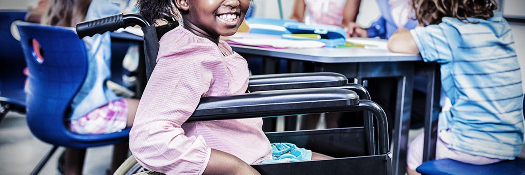 Disabled schoolgirl smiling in classroom at school