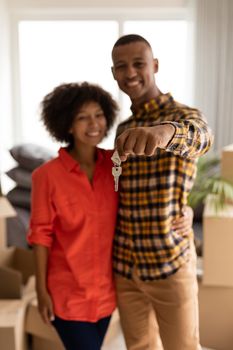 Portrait of Happy African american couple holding new house keys in living room at home