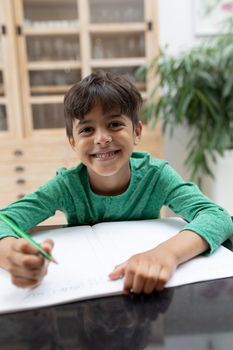 Portrait of African american boy doing his homework on a table at home