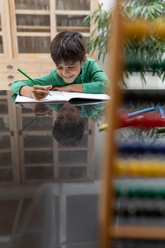 Front view of African american boy doing his homework on a table at home