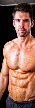 Portrait of shirtless male athlete standing in gym