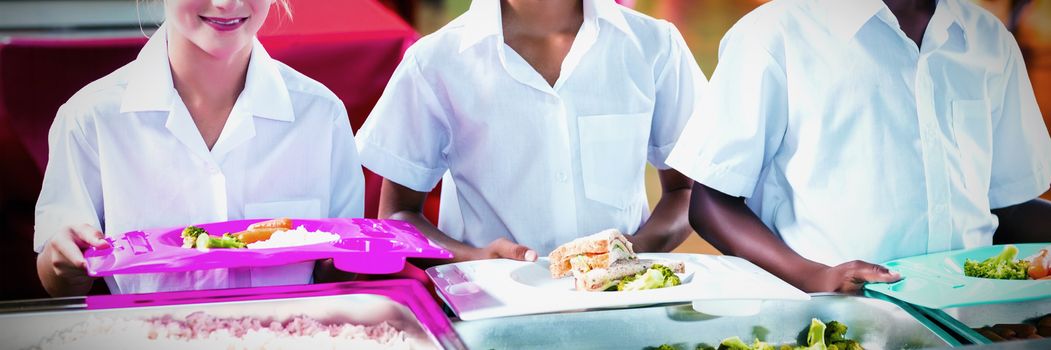 Portrait of school kids having lunch during break time in school cafeteria