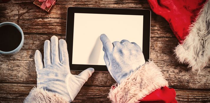 Close-up of Santa Claus using digital tablet on table