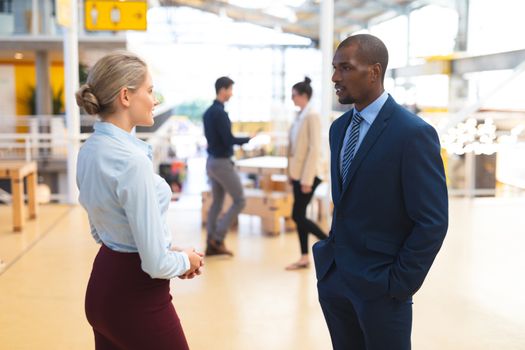 Side view of diverse business people interacting with each other in corridors at office. International diverse corporate business partnership concept