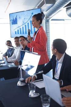 Side view of asian female speaker speaks in a business seminar. International diverse corporate business partnership concept