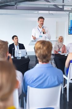 Front view of Caucasian male speaker speaks in a business seminar at conference meeting. International diverse corporate business partnership concept