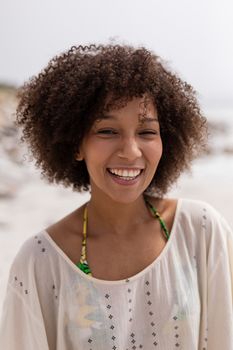 Portrait of happy African american woman standing on the beach