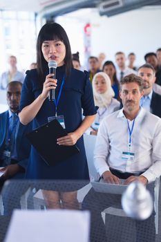 Front view of Asian Business woman asking question in business seminar. International diverse corporate business partnership concept