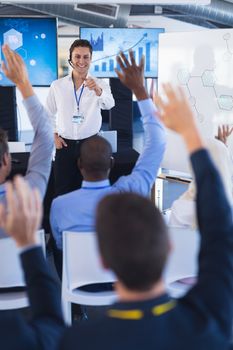 Rear view of Male speaker questioning business people in business seminar. International diverse corporate business partnership concept