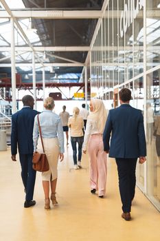 Rear view of diverse Business people walking together in the corridor at office. International diverse corporate business partnership concept