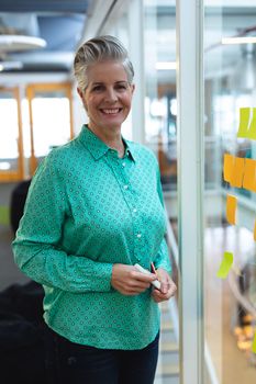 Portrait of happy Caucasian female executive smiling in office. This is a casual creative start-up business office for a diverse team